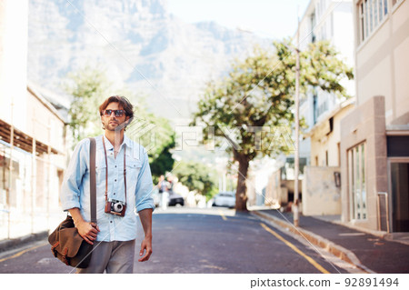 Go exploring. Shot of a handsome young tourist checking out the sights. Go exploring. Shot of a handsome young tourist checking out the sights. 92891494