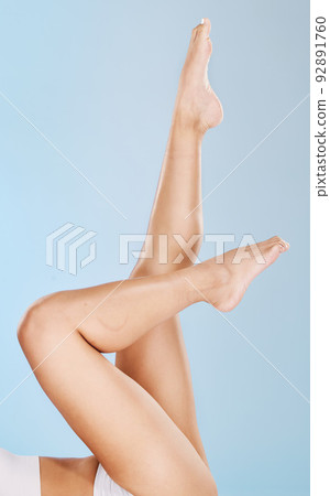 Closeup of a woman posing in underwear against a blue studio background. One female only feeling confident while showing her hairless, smooth legs after hair removal, waxing or epilation Closeup of a woman posing in underwear against a blue studio background. One female only feeling confident while showing her hairless, smooth legs after hair removal, waxing or epilation 92891760