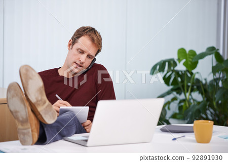 If you leave a number I can call you back tomorrow.... A handsome businessman working at his desk. 92891930