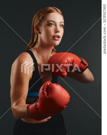 Its all about discipline. Studio shot of a sporty young woman wearing boxing gloves against a black background. 92892560