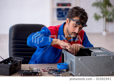 Young male repairman repairing computer 92892941