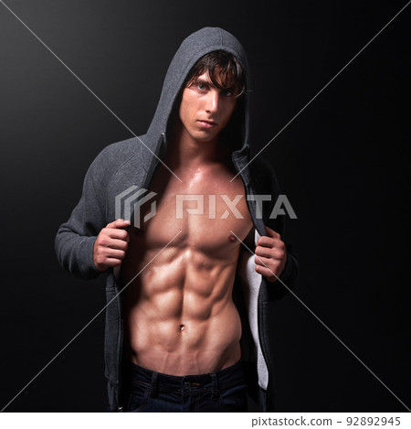 This is what hard work and dedication look like. Studio shot of a handsome bare-chested young athlete standing against a black background. 92892945