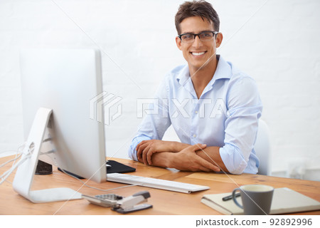Ill take care of all your website needs. Portrait of a smiling businessman sitting at his desk. Ill take care of all your website needs. Portrait of a smiling businessman sitting at his desk. 92892996