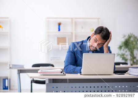 Young male employee working in the office Young male employee working in the office 92892997