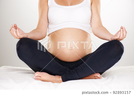 Two souls connected. Cropped shot of a pregnant woman meditating in the lotus position. Two souls connected. Cropped shot of a pregnant woman meditating in the lotus position. 92893157