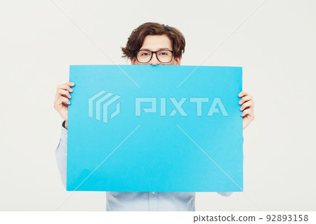Come on over and put your copy here. A young man holding a blue placard up for your copyspace. Come on over and put your copy here. A young man holding a blue placard up for your copyspace. 92893158