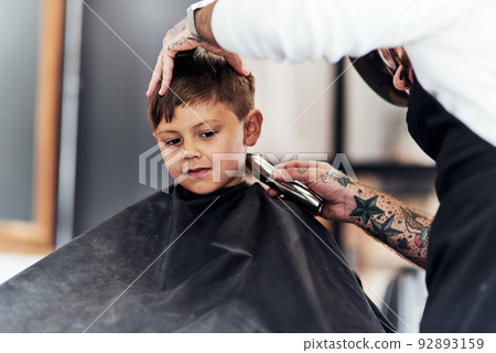 Big boys dont cry when they get a haircut. Cropped shot an adorable little boy getting a haircut at the barbershop. Big boys dont cry when they get a haircut. Cropped shot an adorable little boy getting a haircut at the barbershop. 92893159