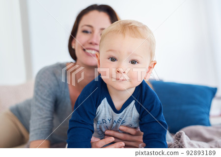Hes a happy little handful. Portrait of a mother bonding with her baby boy at home. Hes a happy little handful. Portrait of a mother bonding with her baby boy at home. 92893189
