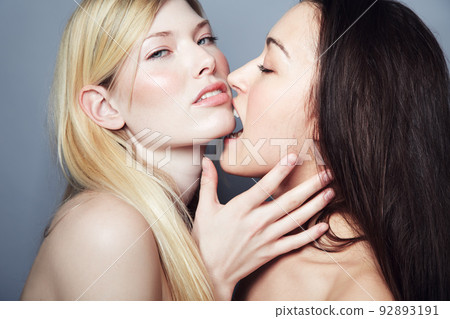 Tasting the forbidden fruit. Sensual shot of a brunette woman biting a blonde womans chin. Tasting the forbidden fruit. Sensual shot of a brunette woman biting a blonde womans chin. 92893191
