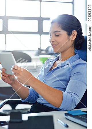 Connecting with a client online. Shot of a young businesswoman using a digital tablet at work. Connecting with a client online. Shot of a young businesswoman using a digital tablet at work. 92893193