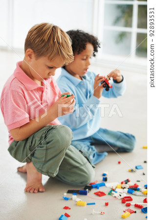 How do these pieces fit together. Two cute young boys playing with building blocks on the flor. How do these pieces fit together. Two cute young boys playing with building blocks on the flor. 92893531