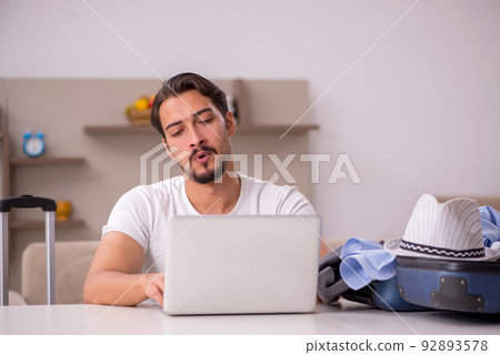 Young man preparing for trip at home Young man preparing for trip at home 92893578