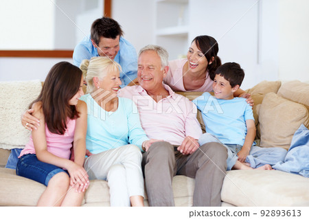 Enjoying grannys joke together. A loving family laughing on a lounge sofa together. 92893613