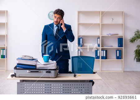 Young male employee preparing for business trip at workplace 92893661