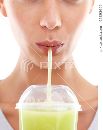 This really tastes so good. Studio shot of a beautiful young woman enjoying a fruit smoothie. 92893693