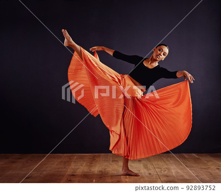 Free form dancing. Female contemporary dancer in a dramatic pose against dark background. Free form dancing. Female contemporary dancer in a dramatic pose against dark background. 92893752