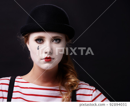 Allow me to mime a sad story. Studio shot of a female mime. 92894031