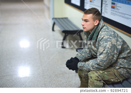 The call of dutyday 1. Shot of a young soldier sitting on a bench in the hall of a military academy. The call of dutyday 1. Shot of a young soldier sitting on a bench in the hall of a military academy. 92894721