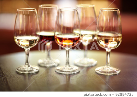 The many varieties of wine. Shot of five glasses of different wines on a table. 92894723
