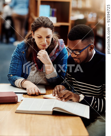 Turn to the next page. Shot of a group of university students working in the library at campus. Turn to the next page. Shot of a group of university students working in the library at campus. 92894725