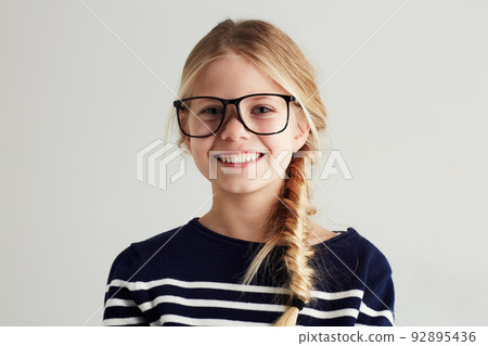 Shes got a bright future ahead. Portrait of a cute girl giving you a toothy smile while wearing hipster glasses. Shes got a bright future ahead. Portrait of a cute girl giving you a toothy smile while wearing hipster glasses. 92895436