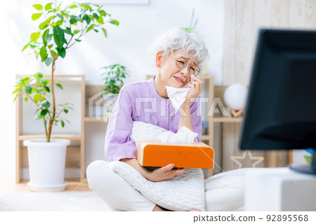 A senior woman who is impressed by watching TV 92895568