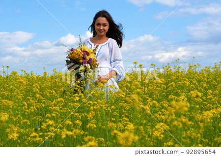 a girl in the national costume of Ukraine in a field of flowers 92895654