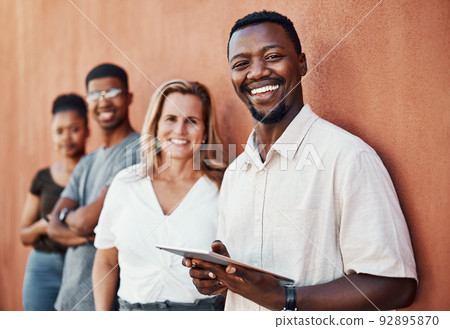 Welcome to the digital age. Cropped portrait of a handsome young businessman standing with his colleagues outside and using a tablet. Welcome to the digital age. Cropped portrait of a handsome young businessman standing with his colleagues outside and using a tablet. 92895870