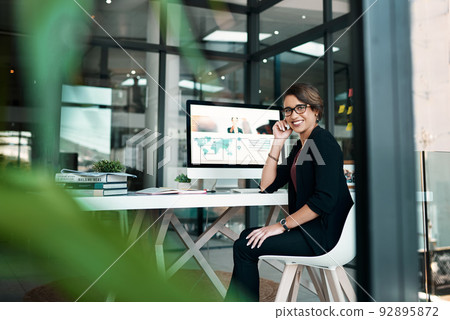 Anything is possible if youre prepared to work for it. Cropped portrait of an attractive young businesswoman sitting alone at her desk in her office. Anything is possible if youre prepared to work for it. Cropped portrait of an attractive young businesswoman sitting alone at her desk in her office. 92895872
