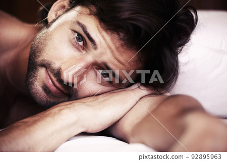 A face youd want to wake up to.... Young sexy male lying in bed and looking towards the camera - closeup. 92895963