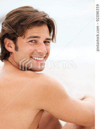 Happiness is a day at the beach. Shot of a handsome young man enjoying a relaxing day at the beach. Happiness is a day at the beach. Shot of a handsome young man enjoying a relaxing day at the beach. 92896359