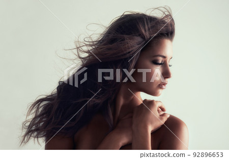 Simple is beautiful. Studio shot of a gorgeous young woman posing topless against a grey background. 92896653