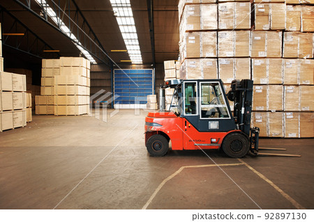 Our service is shipping good. A large warehouse storing big wooden boxes with a forklift. 92897130