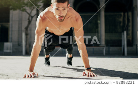 Be the strongest you can be. Shot of a young man doing pushups during his workout in the city. Be the strongest you can be. Shot of a young man doing pushups during his workout in the city. 92898221