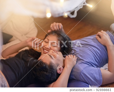 We love spending time together. Cropped shot of an affectionate young couple relaxing at home. 92898661