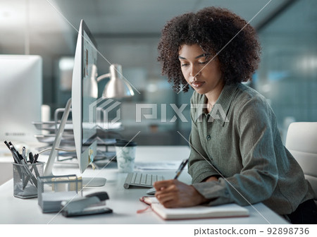 Well noted. Shot of a young focused female agent working in a call centre taking notes. 92898736