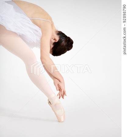 Nothing but elegance. Dedicated young ballerina dancing en pointe against a white background. 92898790