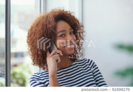 Making connections. Shot of a young woman talking on the phone in an office. 92899270