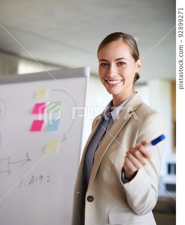 She knew how to work a room. A young woman gesturing with her hand while standing in her office doing a presentation. 92899271