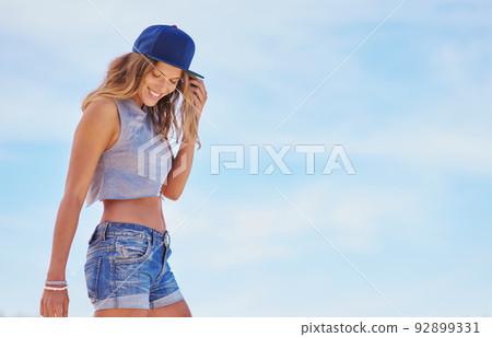 Cool summer style. Shot of a young woman enjoying a day outside. 92899331