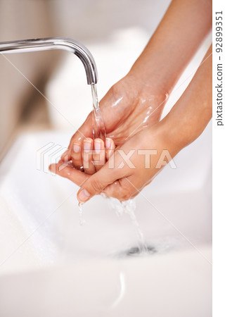 Hygiene starts with the hands. Shot of a young woman washing her hands in a bathroom. Hygiene starts with the hands. Shot of a young woman washing her hands in a bathroom. 92899351
