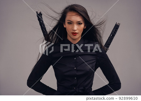 Upholding the samurai way. Cropped studio portrait of a beautiful young woman in a martial arts outfit wielding two samurai swords. 92899610