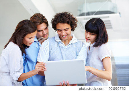 Presentation and teamwork - Technology. A group of young entrepreneurs having a business meeting over a laptop. 92899762