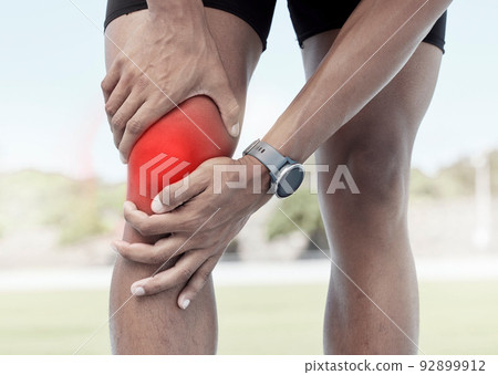 Closeup of one sportsman holding his sore knee in glowing red. Uncomfortable athlete suffering from a painful leg injury and inflamed muscles during workout. Muscle strain due to overexertion 92899912