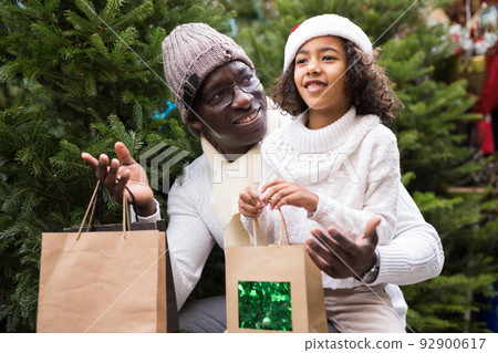 Small positive girl with father buying Christmas tree 92900617