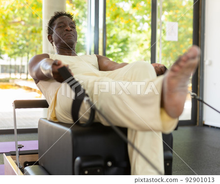 Man doing exercises on pilates reformer 92901013