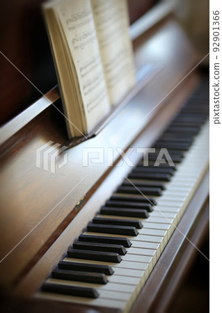 Closeup of a vintage piano and keyboard with a sheet music book. An empty antique or wooden musical instrument for playing classical jazz or used for old traditional songwriting and rehearsals Closeup of a vintage piano and keyboard with a sheet music book. An empty antique or wooden musical instrument for playing classical jazz or used for old traditional songwriting and rehearsals 92901366