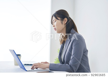 Tired businesswoman in front of laptop in office Tired businesswoman in front of laptop in office 92901685