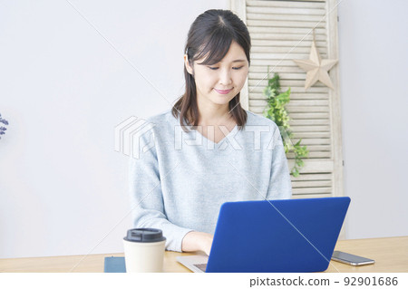 A woman using a laptop at home A woman using a laptop at home 92901686