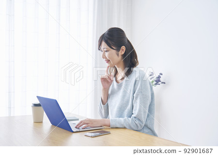woman looking at laptop at home 92901687